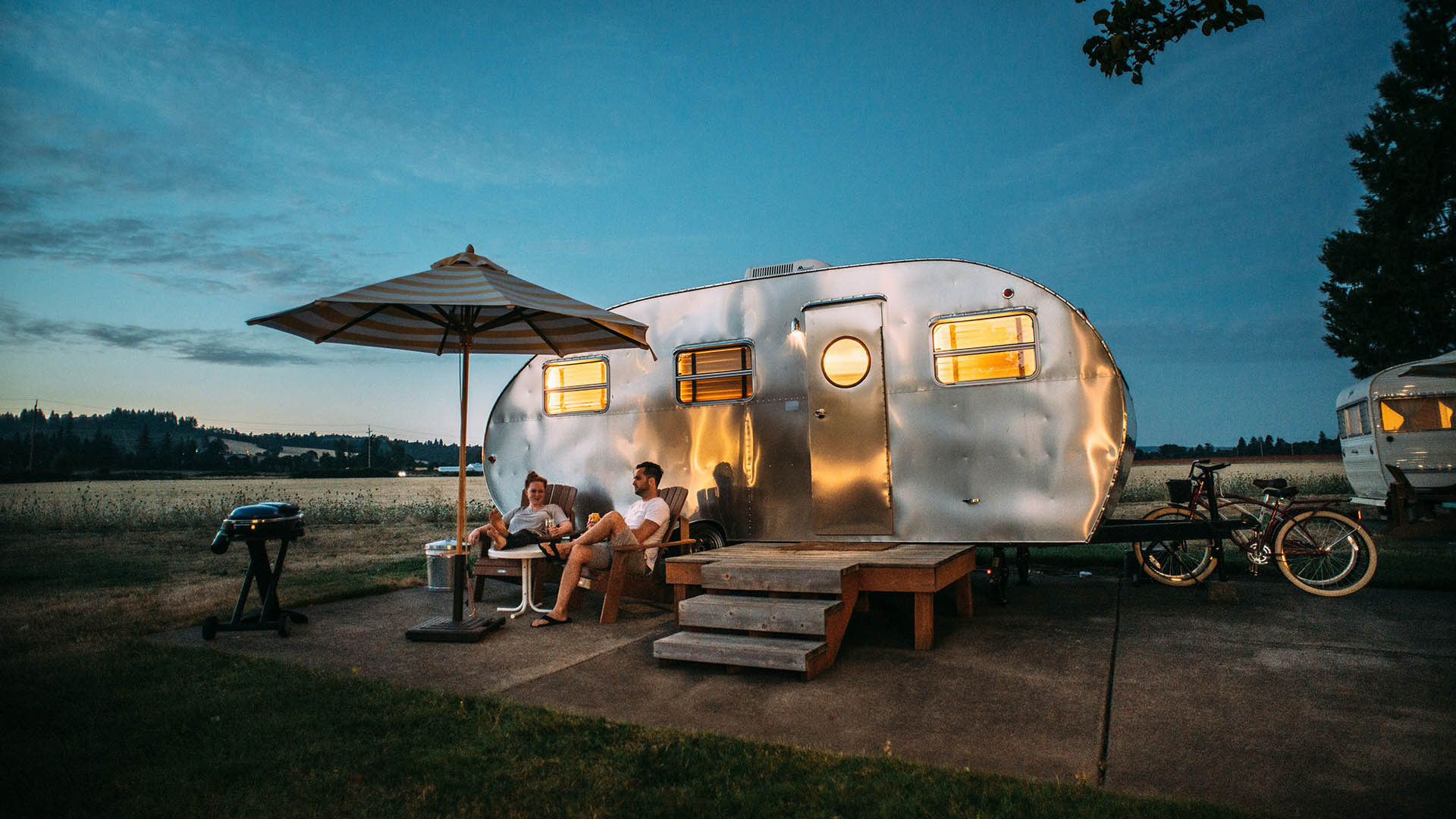 Bild eines Paars vor einem Campingwagen Camping 2025 Reisekompass