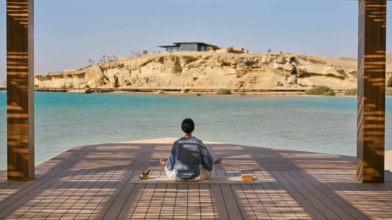 Das Bild zeigt eine Frau beim Yoga im Hotel Six Senses Amaala in Saudi-Arabien